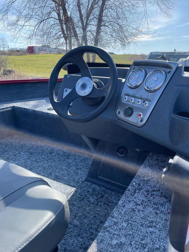 Slide: The Image of 2025 Tracker Pro Guide V-16 SC boat interior with steering wheel and dashboard controls. - 2