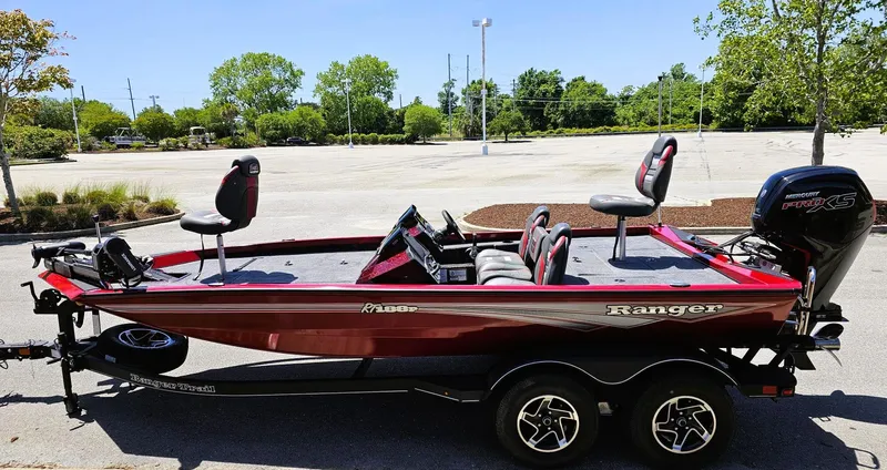 Slide: The Image of 2025 Ranger RT188P fishing boat with red exterior, parked in a sunny lot. - 11
