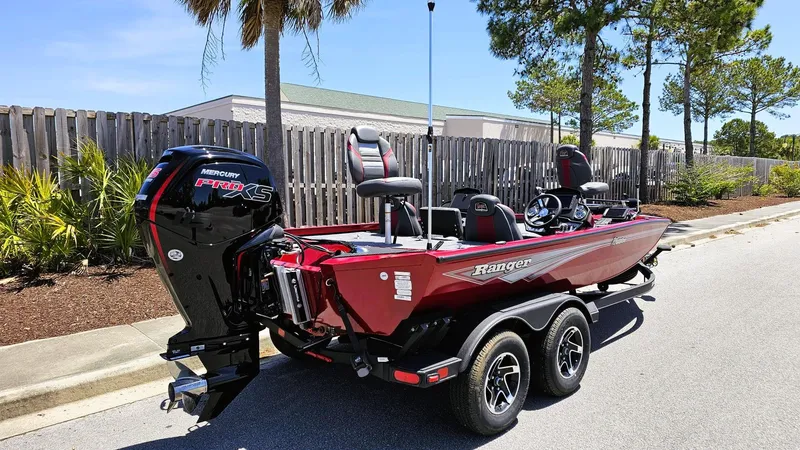 Slide: The Image of 2025 Ranger RT188P boat with Mercury engine, parked on a sunny street. - 2