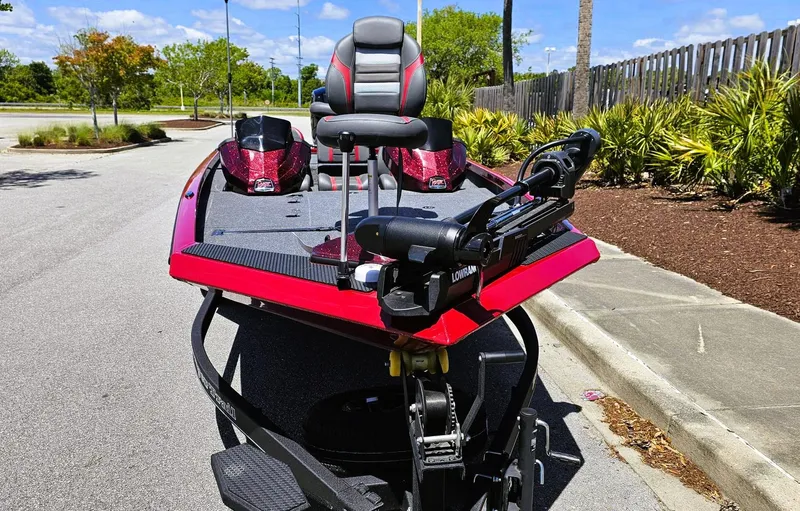Slide: The Image of 2025 Ranger RT188P boat, red and black, parked on a sunny street. - 7