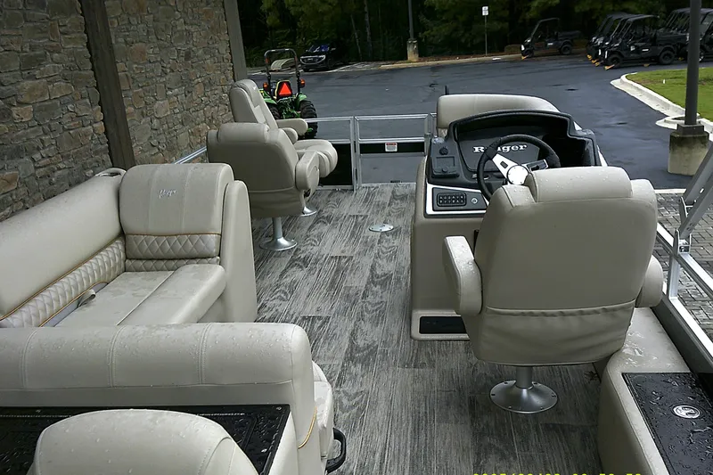Slide: The Image of 2025 Ranger Reata 220FC boat interior with beige seating and modern dashboard. - 5