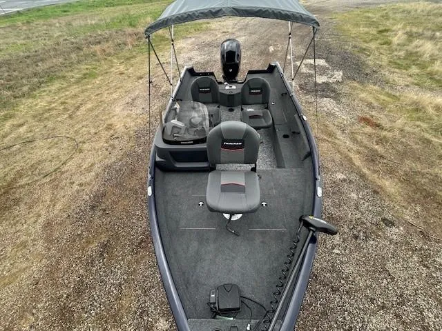 Slide: The Image of 2025 Tracker Pro Guide V-16 SC fishing boat with canopy on gravel. - 12