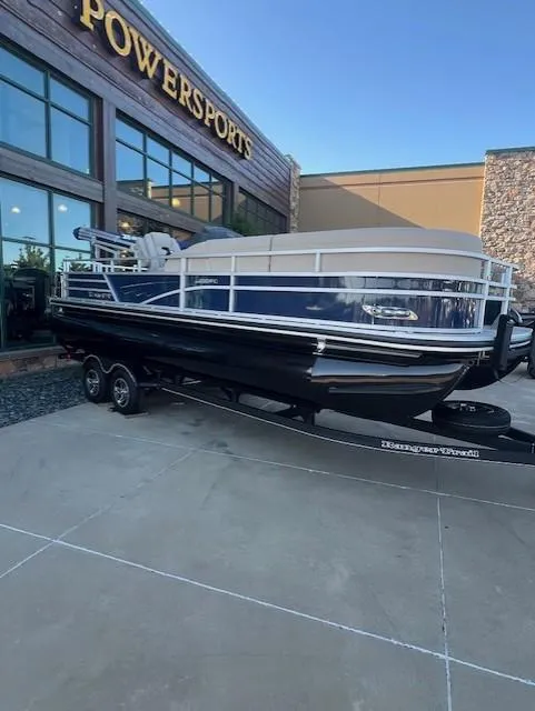 The Image of 2025 Ranger Reata 220FC boat parked outside a building with large windows. - 0