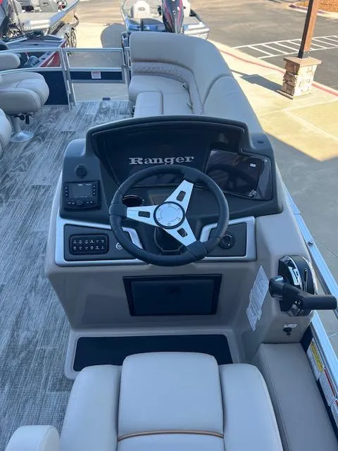 Slide: The Image of 2025 Ranger Reata 220FC boat interior with steering wheel and seating. - 2