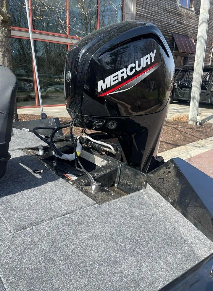 Slide: The Image of 2025 Tracker Pro Team 175 boat with Mercury engine, parked outdoors. - 6