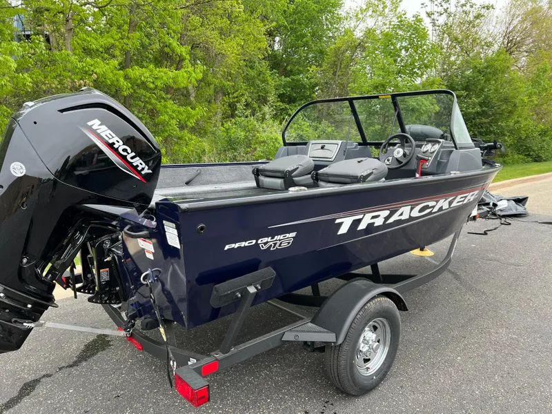 Slide: The Image of 2025 Tracker Pro Guide V-16 WT boat with Mercury engine on trailer, parked outdoors. - 4