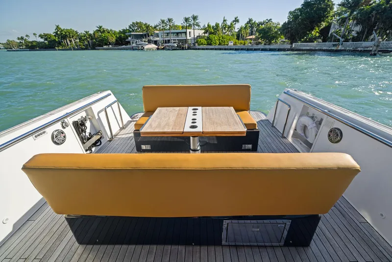 Slide: The Image of Fjord 40 Open 2011 boat with tan seating and table, on calm water near shoreline. - 35