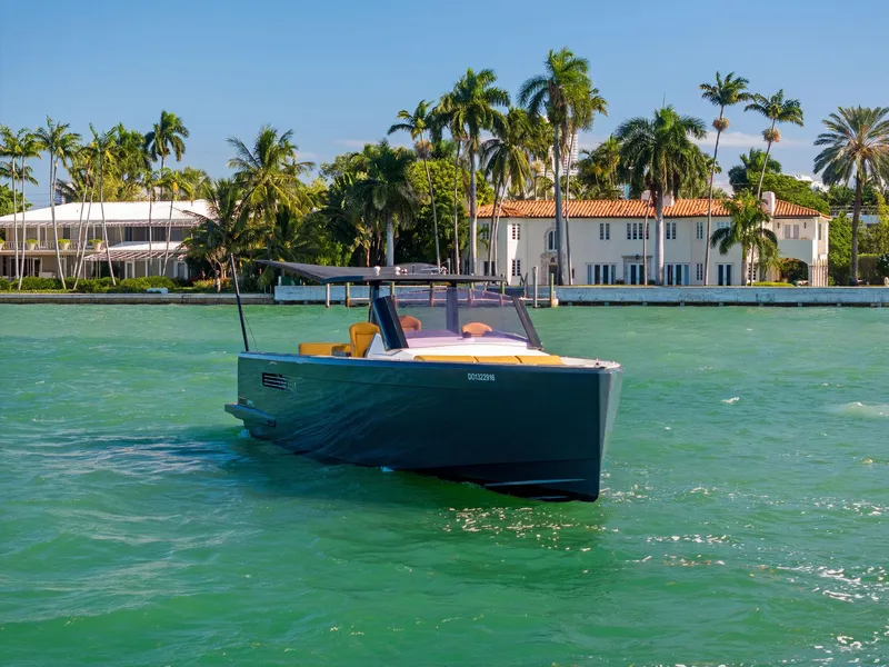 Slide: The Image of 2011 Fjord 40 Open yacht cruising on turquoise water near palm-lined luxury homes. - 49