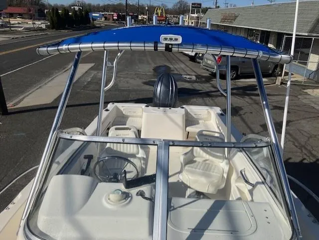 Slide: The Image of 2005 Sea Hunt Victory 225 boat with blue canopy and white interior, parked on street. - 15