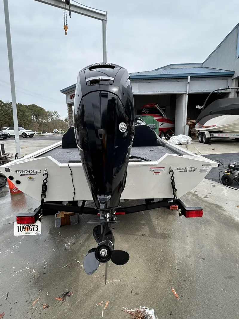 Slide: The Image of 2022 Bass Tracker PRO TEAM 175 TXW boat, rear view with motor, parked outdoors. - 13