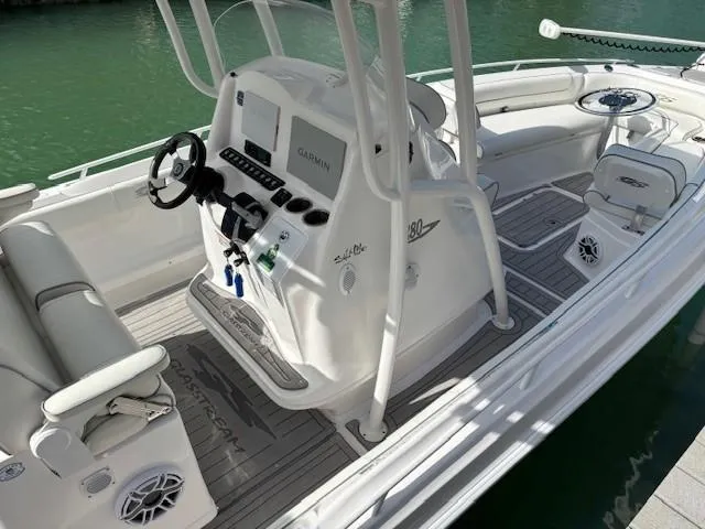 Slide: The Image of 2023 Glasstream 280 Pro-XS boat interior with steering console and seating, docked on water. - 23