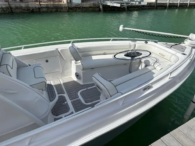Slide: The Image of 2023 Glasstream 280 Pro-XS boat interior with seating and steering wheel, docked on green water. - 28