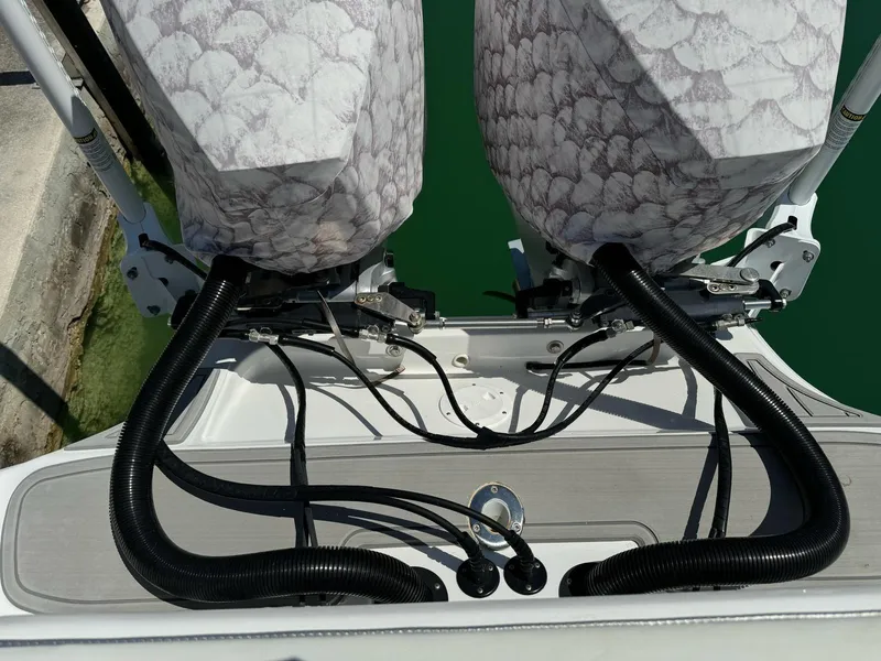 Slide: The Image of 2023 Glasstream 280 Pro-XS boat engines with protective covers and cables, docked in water. - 5