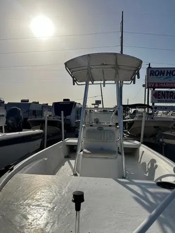 Slide: The Image of 2010 Mako 18 Inshore boat with T-top, docked under a bright sun. - 4