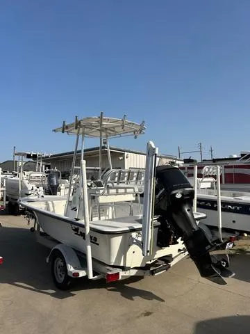 Slide: The Image of 2010 Mako 18 Inshore boat with outboard motor on trailer, parked outdoors. - 5
