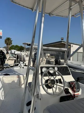 Slide: The Image of 2010 Mako 18 Inshore boat with steering console and canopy, docked outdoors. - 7