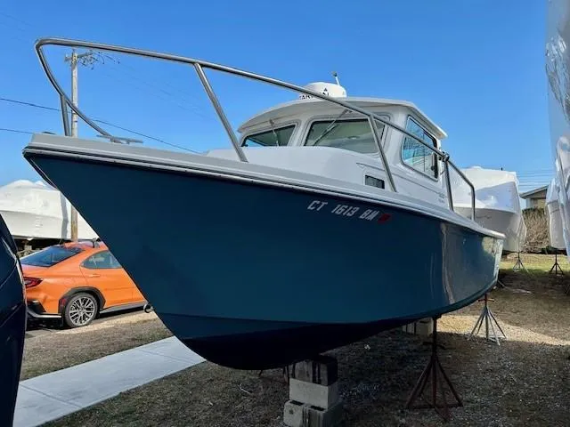 Slide: The Image of 2020 Parker 2320 SL Sport Cabin boat on stands, blue hull, parked outdoors. - 4