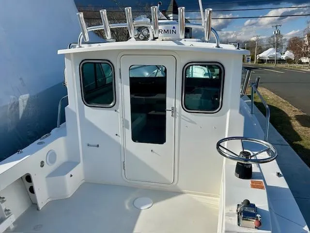 Slide: The Image of 2020 Parker 2320 SL Sport Cabin boat with steering wheel and rod holders. - 5