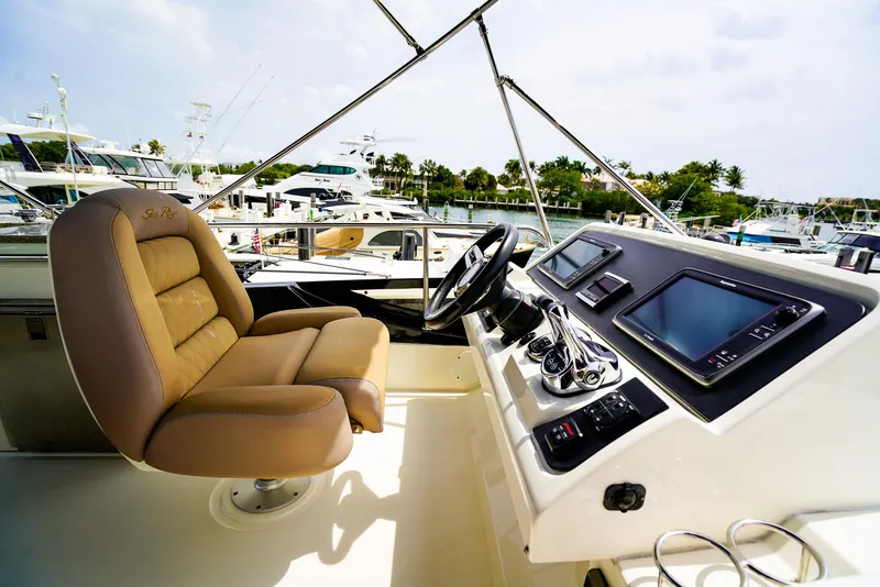 Slide: The Image of Flybridge helm of 2016 Sea Ray 400 Fly yacht with luxurious seating and advanced navigation systems. - 13
