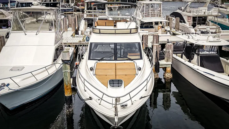 Slide: The Image of 2016 Sea Ray 400 Fly yacht docked among other boats at a marina. - 2