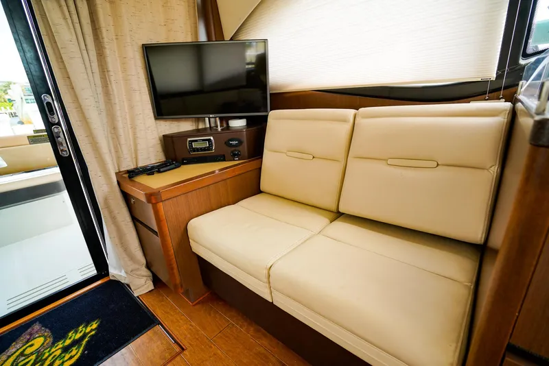 Slide: The Image of Interior of 2016 Sea Ray 400 Fly yacht with beige seating and TV. - 27