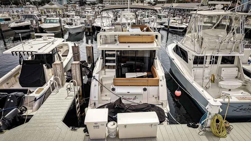 Slide: The Image of 2016 Sea Ray 400 Fly yacht docked among other boats in a marina. - 3