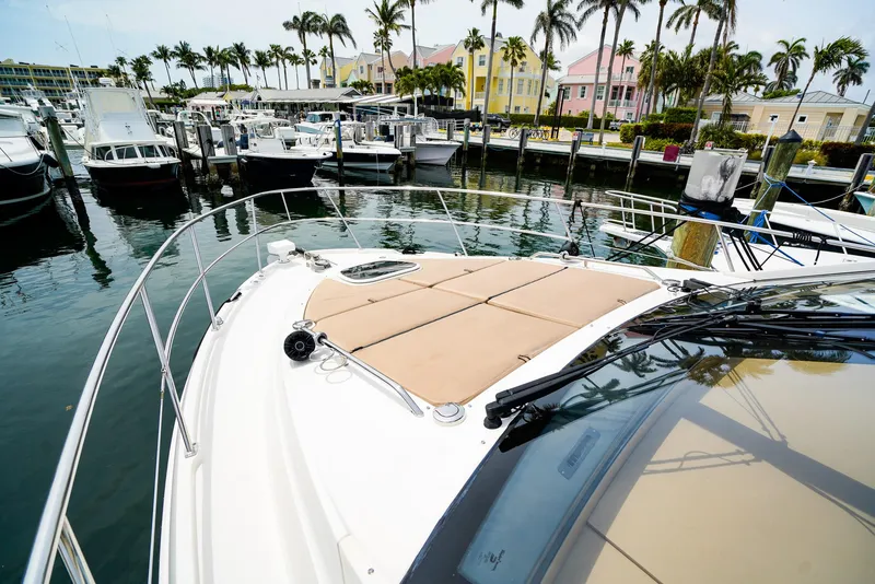 Slide: The Image of 2016 Sea Ray 400 Fly yacht docked in a marina with palm trees and colorful buildings. - 6