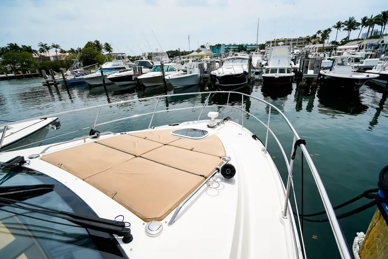 Slide: The Image of 2016 Sea Ray 400 Fly yacht docked in a marina with other boats. - 9