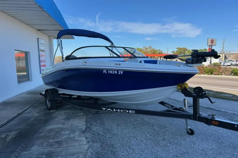 Slide: The Image of 2021 Tahoe 450 TF boat on trailer, parked outside a building under a blue sky. - 3