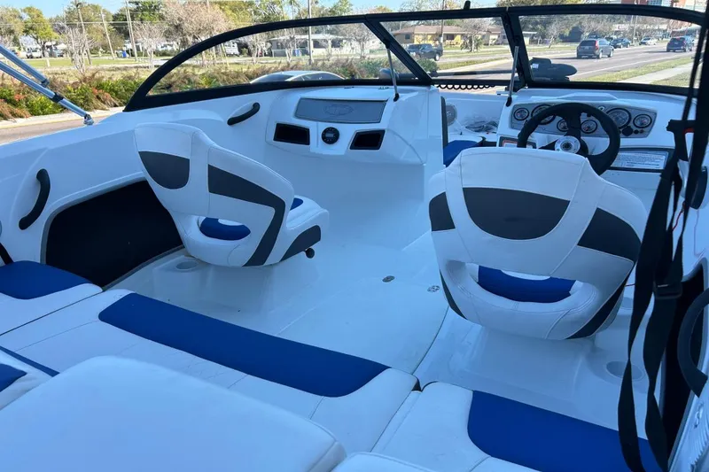 Slide: The Image of 2021 Tahoe 450 TF boat interior with white and blue seating, dashboard, and steering wheel. - 9