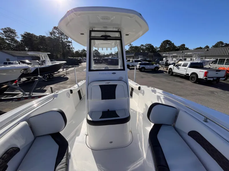 Slide: The Image of 2025 Tidewater 232 CC Adventure boat interior with seating, parked outdoors. - 13