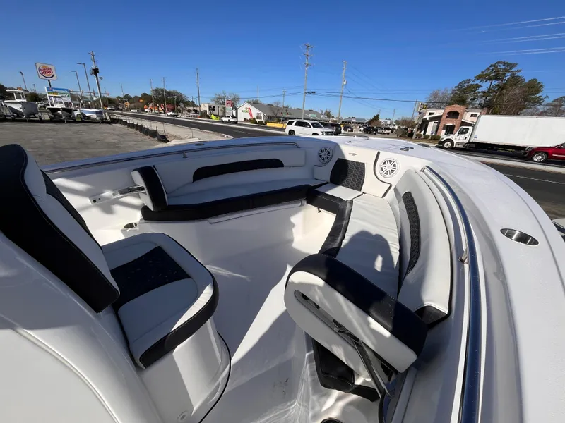 Slide: The Image of 2025 Tidewater 232 CC Adventure boat interior with seating and speakers, parked outdoors. - 14