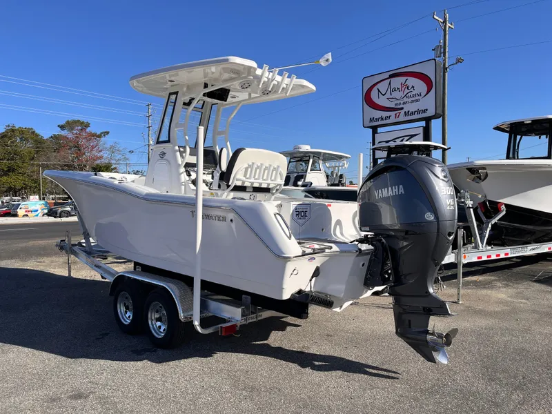 Slide: The Image of 2025 Tidewater 232 CC Adventure boat on trailer, featuring Yamaha outboard motor, at a dealership. - 2
