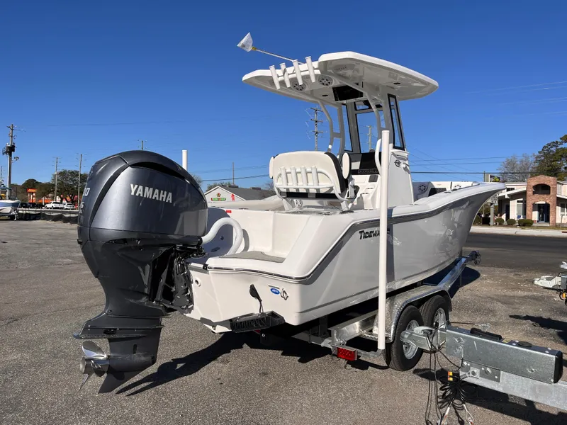 Slide: The Image of 2025 Tidewater 232 CC Adventure boat on trailer with Yamaha outboard motor, parked outdoors. - 4