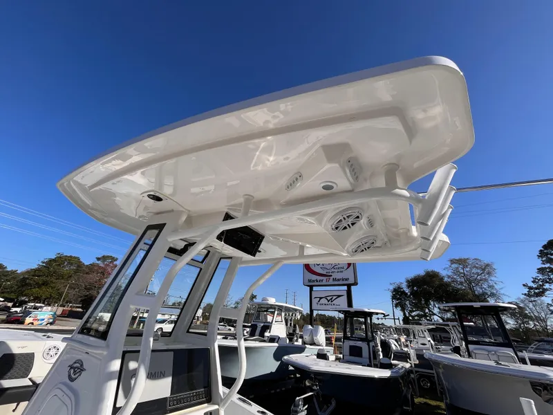 Slide: The Image of 2025 Tidewater 232 CC Adventure boat with T-top under clear blue sky. - 9