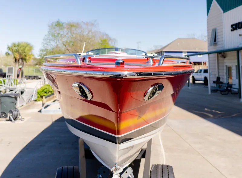 Slide: The Image of 2017 Formula 382 FASTech boat with vibrant red and yellow design, parked outdoors. - 2