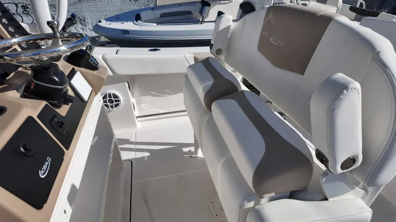 Slide: The Image of 2025 Robalo 232 Explorer boat interior with steering wheel and cushioned seating. - 7