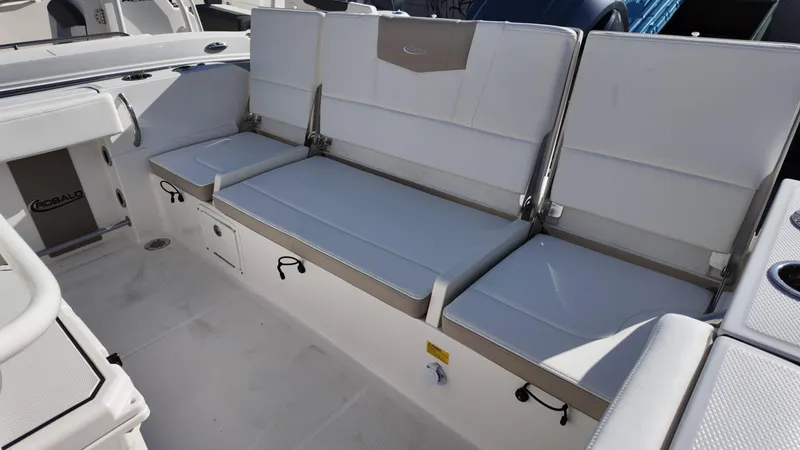 Slide: The Image of 2025 Robalo 232 Explorer boat seating area with white cushioned seats. - 8