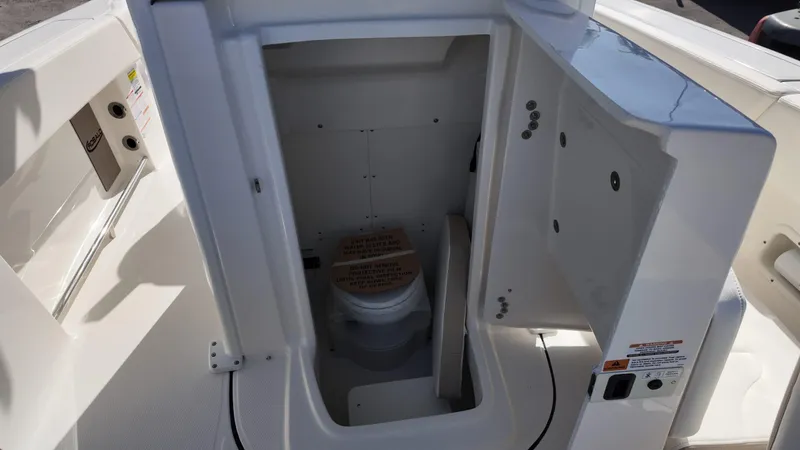 Slide: The Image of 2025 Robalo R250 boat interior with compact marine toilet compartment. - 10