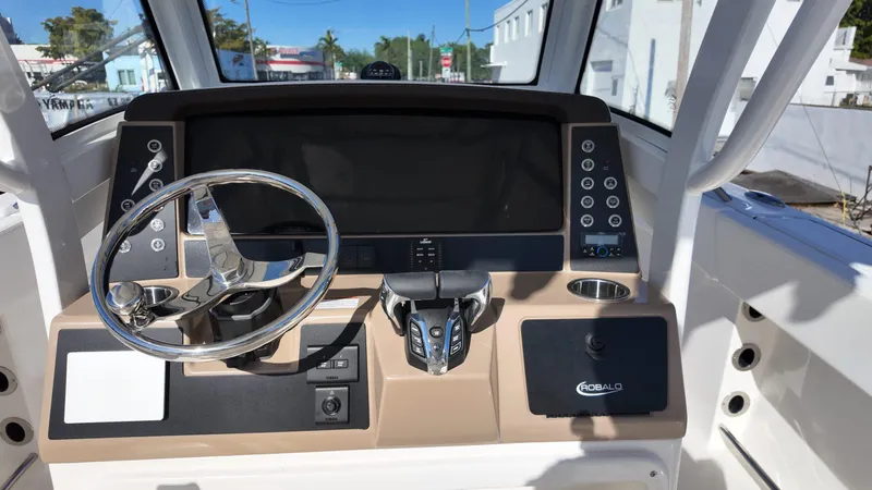 Slide: The Image of 2025 Robalo R250 boat dashboard with steering wheel and control panel. - 11