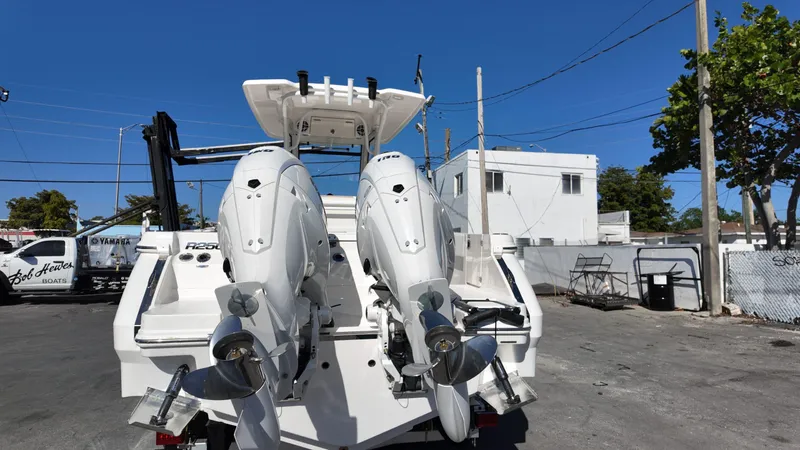 Slide: The Image of 2025 Robalo R250 boat with dual outboard engines in a marina setting. - 19