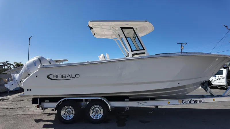 Slide: The Image of 2025 Robalo R250 boat on trailer under clear blue sky. - 4