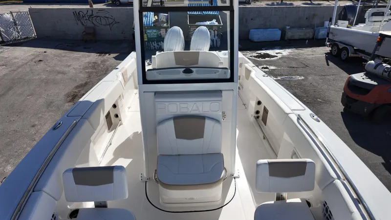 Slide: The Image of 2025 Robalo R250 boat interior with white seating and helm, docked outdoors. - 8