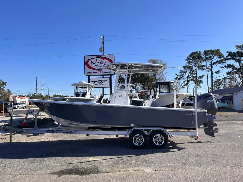 The Image of 2025 Tidewater 2300 Carolina Bay boat on trailer, parked outdoors under clear blue sky. - 0