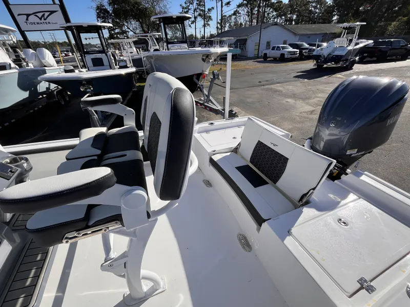 Slide: The Image of 2025 Tidewater 2300 Carolina Bay boat interior with seating and motor, displayed outdoors. - 14