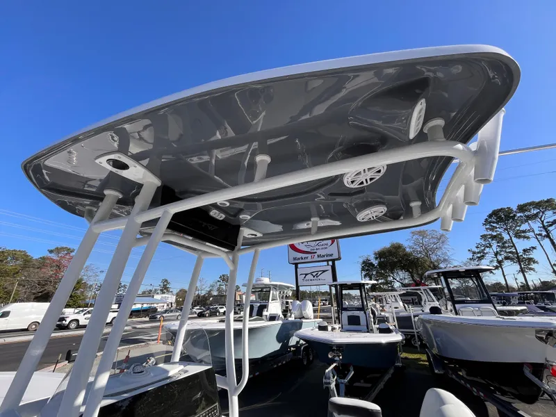 Slide: The Image of 2025 Tidewater 2300 Carolina Bay boat with T-top, displayed outdoors under clear blue sky. - 15