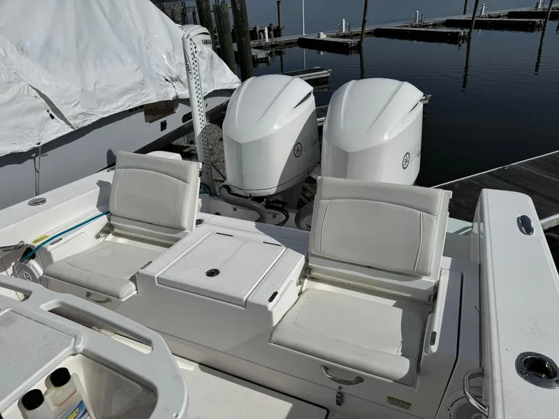 Slide: The Image of 2019 Everglades 273 CC boat with dual engines and white seating at a marina. - 14