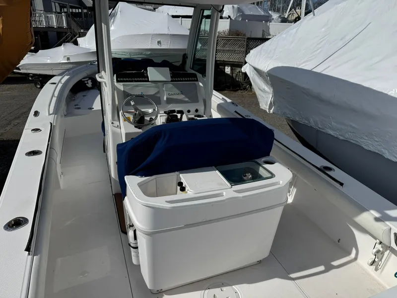 Slide: The Image of 2019 Everglades 273 CC boat interior with console and seating, docked outdoors. - 15