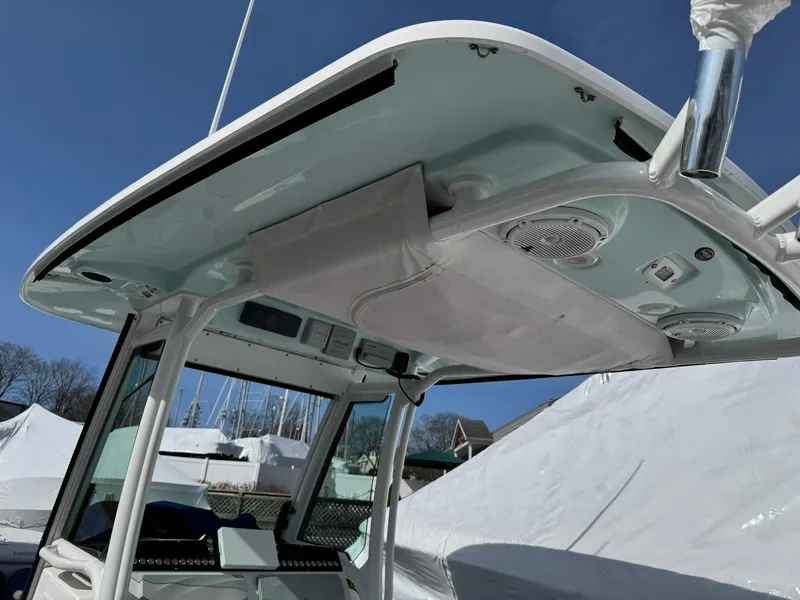 Slide: The Image of 2019 Everglades 273 CC boat with T-top and speakers, docked under clear blue sky. - 17