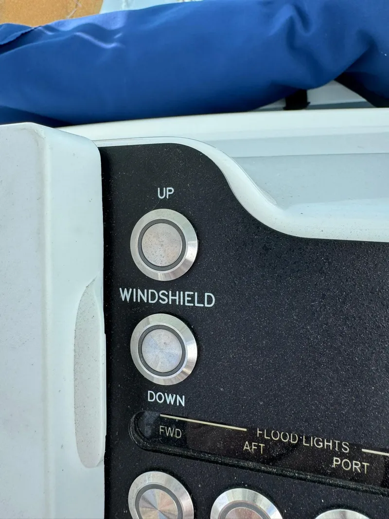 Slide: The Image of Control panel of 2019 Everglades 273 CC boat with windshield and floodlight buttons. - 24